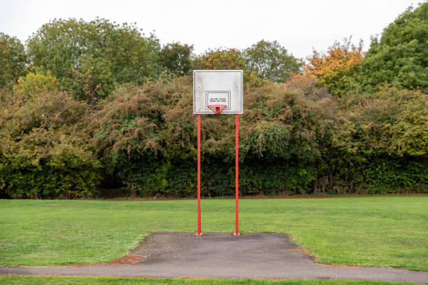 istock empty outdoor basketball field park with trees 1050933928
