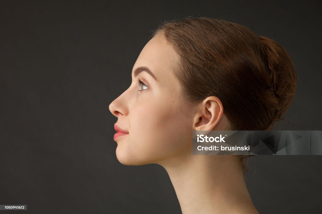 Studio portrait of an attractive 18 year old woman Studio portrait of an attractive 18 year old female ballet dancer on black background Profile View Stock Photo