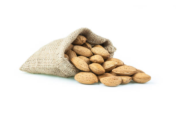 istock Shelled Almonds in burlap sack on white backdrop. heap or stack of almonds. Almond background, healty food for liver and diabetes, hepatic 1050941696