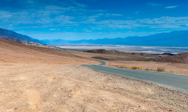 tradizionale american scenic long highway nel parco nazionale delle montagne della valle della morte - arid climate asphalt barren blue foto e immagini stock