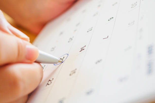 istock calendar page with female hand holding pen 1050964268