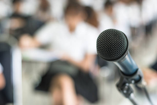 istock Microphone voice speaker with audiences in seminar classroom, lecture hall or conference meeting in educational business event for host, teacher, or coaching mentor 1050964286