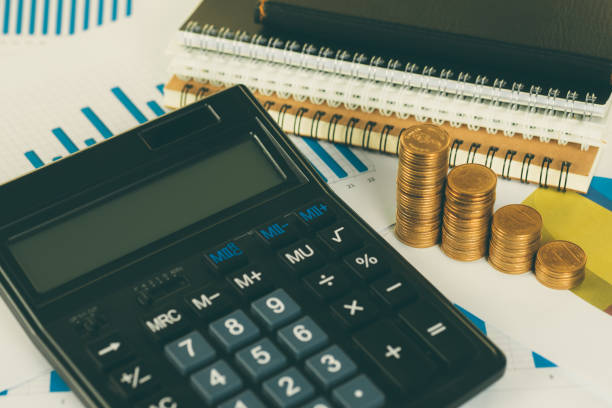 istock Coin stack and financial graph paper sheet with calculator on working table, business planning vision and finance analysis concept. 1050964948
