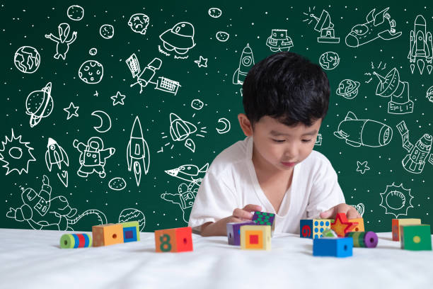istock Asian kid learning by playing with his imagination about science and space adventure, hand drawn on the green chalkboard, education back to school and discovery concept. 1050965036