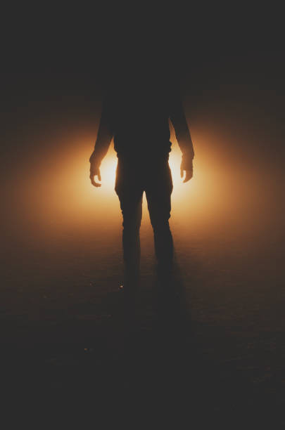istock mysterious silhouette of unknown man standing in darkness 1050967480