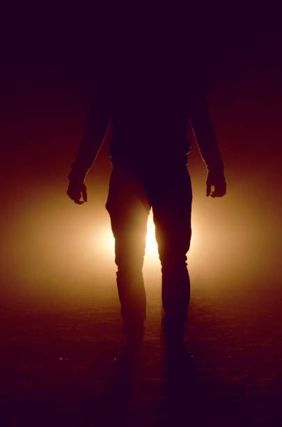 istock mysterious silhouette of unknown man standing in darkness 1050967484