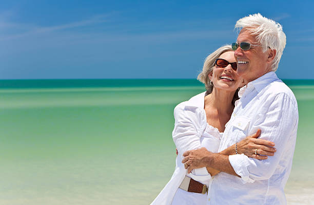 istock Happy senior couple in white on tropical beach 105096954