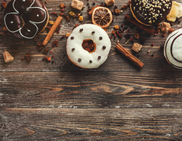 istock Top view of assorted donuts on wooden background with copy space. Selective focus with effects 1050970182