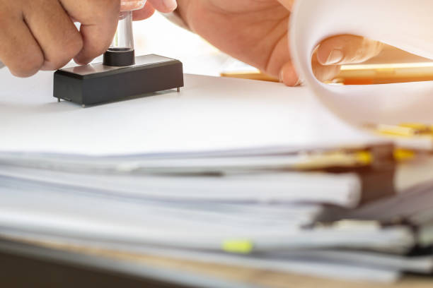 istock Business Person's Hand Stamping On Approved Application Form or Notary public in office stamping documents for signing approval. Business concept 1050970742