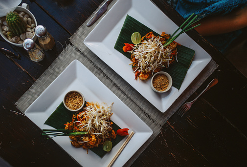 overhead high angle view image of a pad thai with seafood and vegetables in a beach bar on the Koh Phangan island, Thailand.