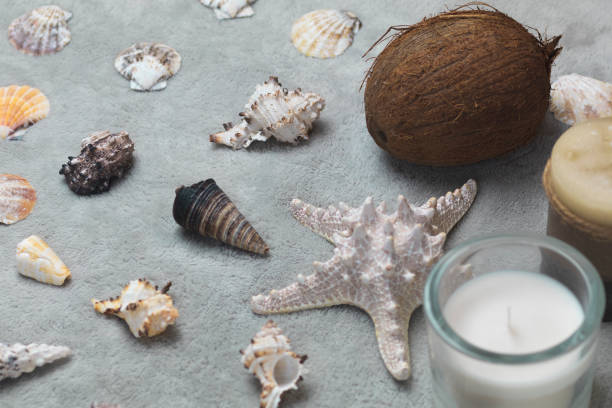 istock Sea shells, coconuts and candles stand on a gray background 1050973548