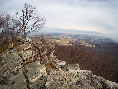 A rocky edge of cliff overlooking a vista of the eastern Pennsylvania.