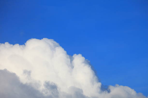 istock Bright blue sky with white fluffy beautiful cloud formation on sunny day for design background and wallpaper 1050981070
