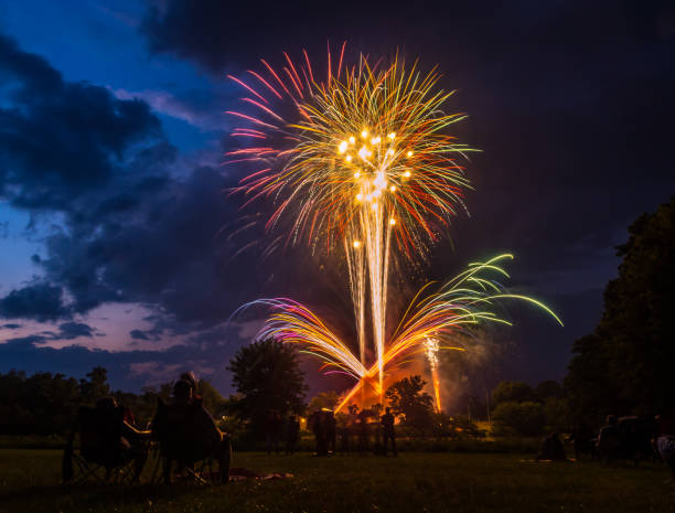 istock Firework Display Above Park, Fourth of July, People Watching 1050981312