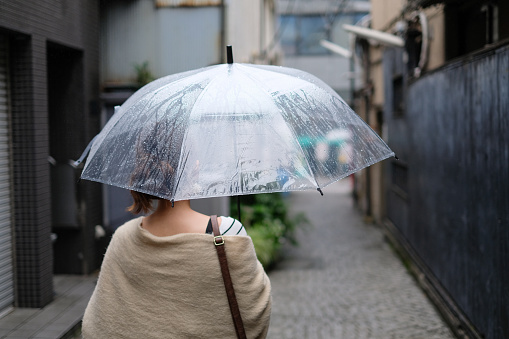 Woman walking in traditional old town of Kagurazaka, Tokyo, in a rainy day