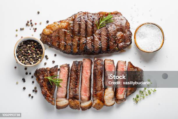 Two Grilled Marbled Beef Steaks Striploin With Spices Isolated On White Background Top View Stock Photo - Download Image Now