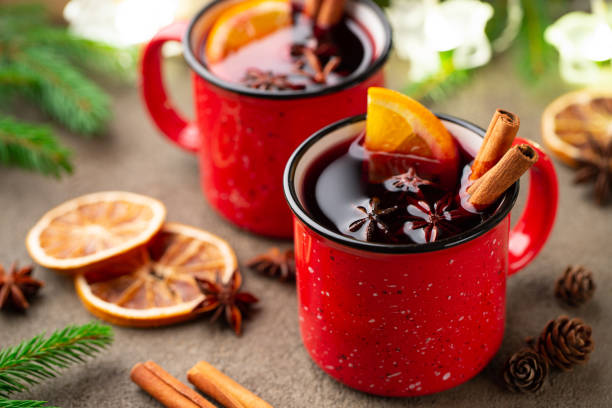 Two cups of christmas mulled wine or gluhwein with spices and orange slices on rustic table top view. Traditional drink on winter holiday Two cups of christmas mulled wine or gluhwein with spices and orange slices on rustic table top view. Traditional drink on winter holiday. mulled wine photos stock pictures, royalty-free photos & images