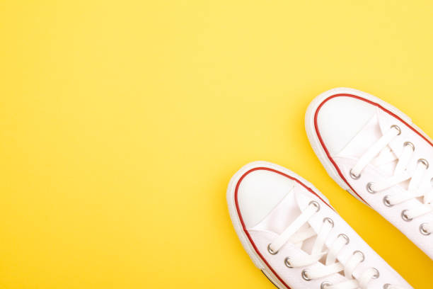 istock White sneakers on the yellow background 1050999848