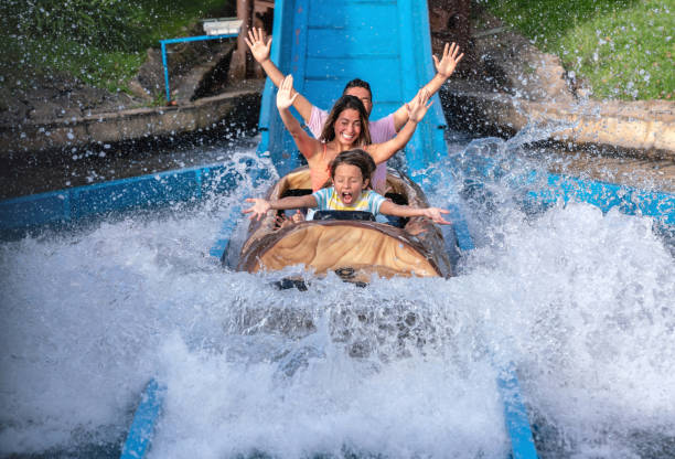 Happy family having fun in an amusement park Happy family having fun in an amusement park riding on a fun water ride - lifestyle concepts amusement park photos stock pictures, royalty-free photos & images