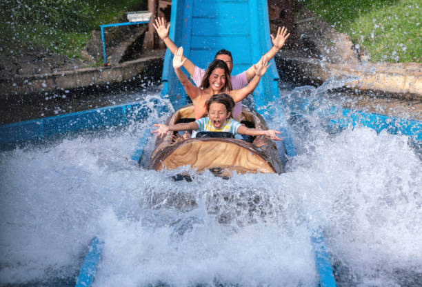 Happy family having fun in an amusement park Happy family having fun in an amusement park riding on a fun water ride - lifestyle concepts amusement park ride stock pictures, royalty-free photos & images