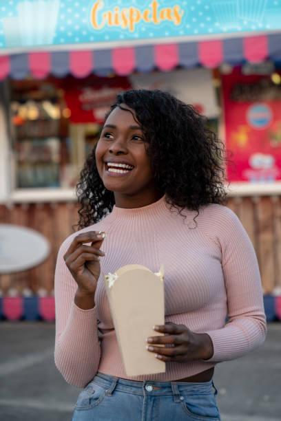 istock Happy woman eating popcorn at an amusement park 1051006142