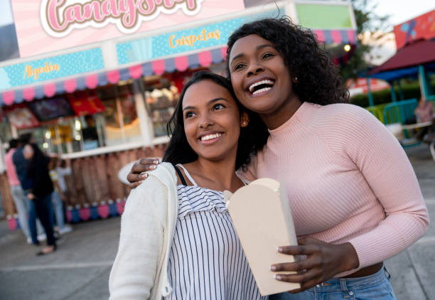 istock Happy women eating popcorn at an amusement park 1051006152
