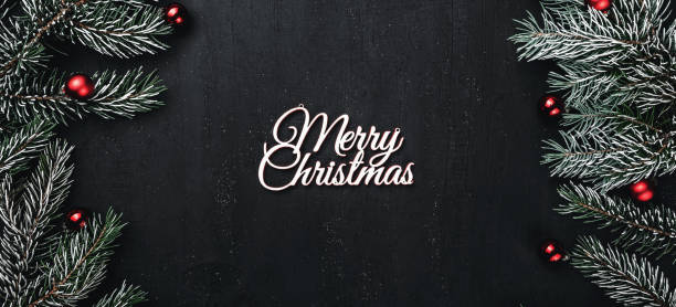 istock Top view from above, evergreen branches, tree globes and white Merry Christmas inscription on black background, with space for text writing, greeting. 1051006586