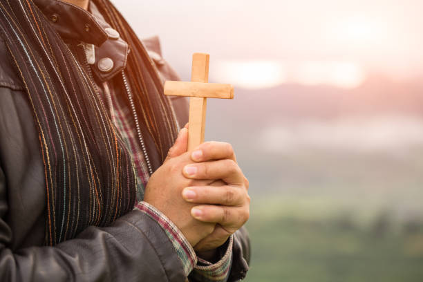 istock Human hand holds cross . Eucharist Therapy Bless God Helping Repent Catholic Easter Lent Mind Pray. Christian concept background. 1051014512