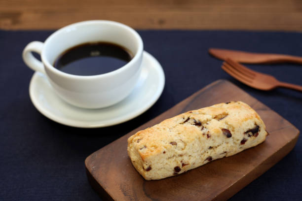 dried fruit scone biscuit with a cup of coffee on wood table