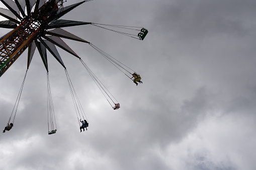 Hoorn, Netherlands, August 10, 2022; Children enjoy the high-speed merry-go-round at the funfair high in the blue sky.