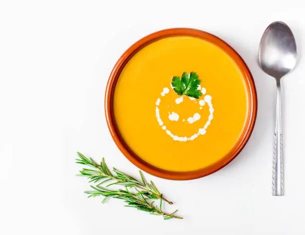 Pumpkin Cream soup isolated on white background. Autumn yellow cream-soup  close up. Top view. Flat lay