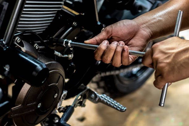 mão que segurava as pessoas estão reparando uma motocicleta. - car workshop service expertise - fotografias e filmes do acervo