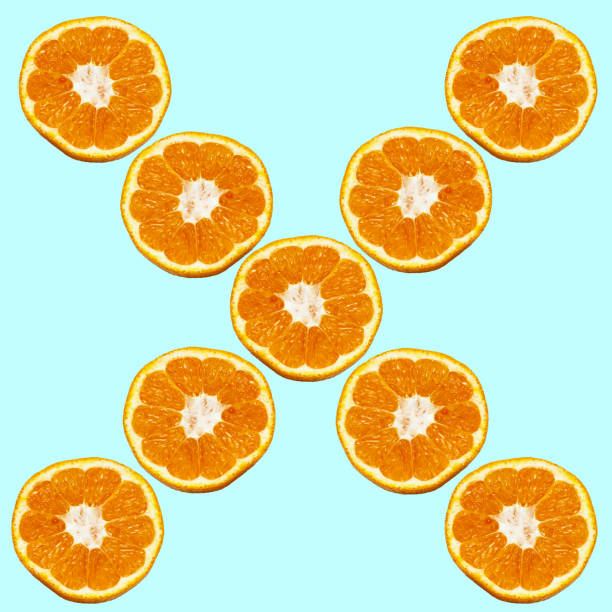 Colorful fruit pattern of fresh orange slices on blue background. From top view