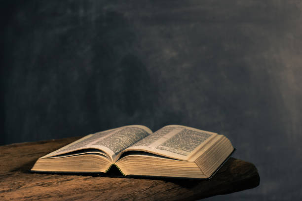 istock Bible on a old oak wooden table. Beautiful dark background.Religion concept 1051064794