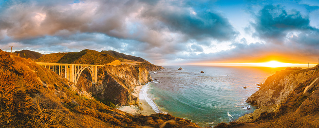Scenic panoramic view of California Central Coast with historic Bixby Creek Bridge along world famous Highway 1 in beautiful golden evening light at sunset, Monterey County, California, USA