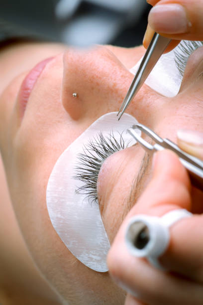 istock Eyelash extension procedure, woman eye with Long eyelashes 1051076084