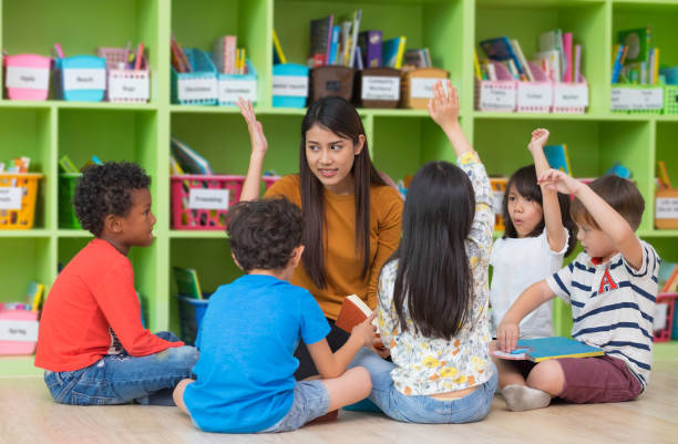 asiático feminino professor ensinando e pedindo raça mista crianças mão acima de responder em sala de aula, conceito de escola do jardim de infância pré. - preschool child preschooler multi ethnic group - fotografias e filmes do acervo