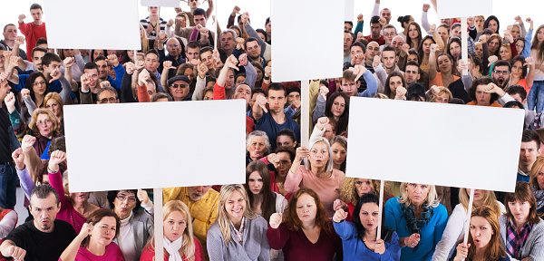 High angle view of large group of unhappy people. Some of them are holding white banners and showing thumbs down. Isolated on white. Copy space.