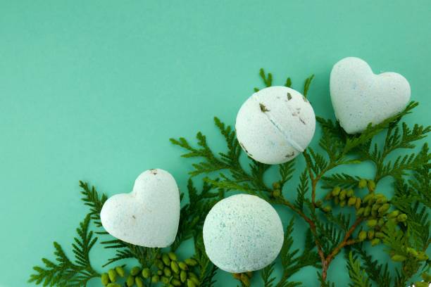 istock thuja bath bombs. body cosmetics with Thuja extract.bath bombs round and heart form with thuja extract and twigs of fresh thuja on green background. 1051086258