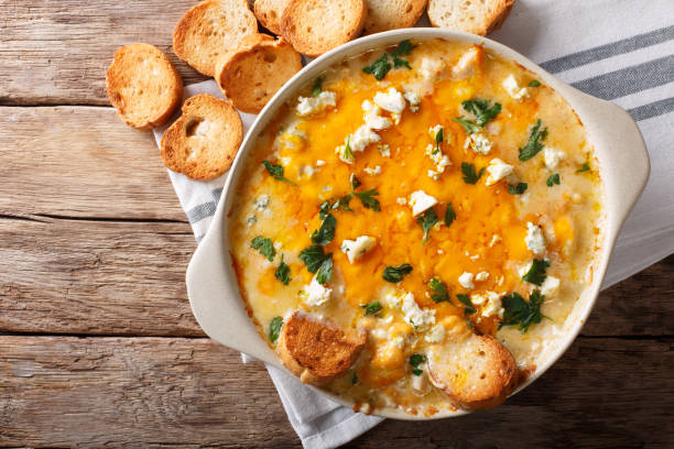 American food: hot chicken buffalo dip close-up in a baking dish with toasted bread. Horizontal top view stock photo