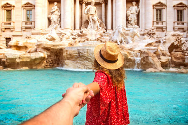 Couple of tourist on vacation in front of Trevi Fountain Italy Romantic woman and man holding hands and walking to Trevi Fountain Rome, Italy. ancient rome photos stock pictures, royalty-free photos & images