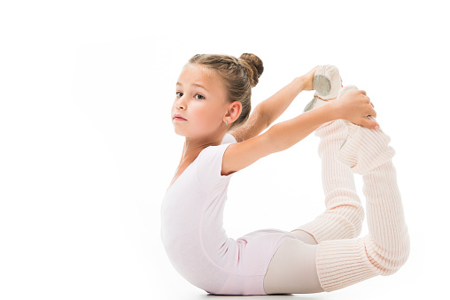beautiful little child doing gymnastics exercises isolated on white background