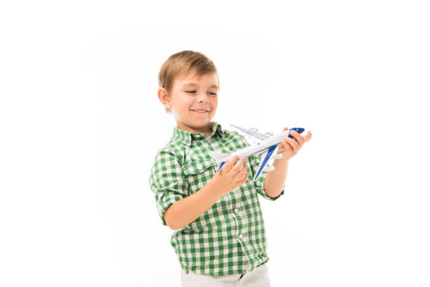 istock smiling little boy playing with toy plane isolated on white background 1051098876