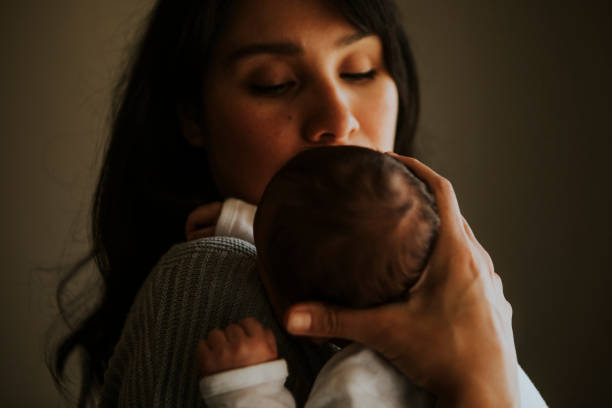 istock Mother holding her baby indoors 1051099554