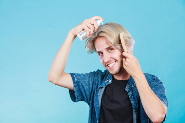 istock Man applying spray cosmetic to his hair 1051099620