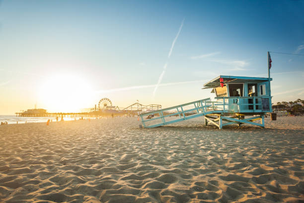 Sunset in Santa Monica Sunset on Santa Monica beach with rescue cabin and amusement park on the background LA Beach stock pictures, royalty-free photos & images