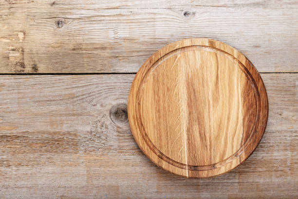 istock Round pizza board on wooden background. 1051107794