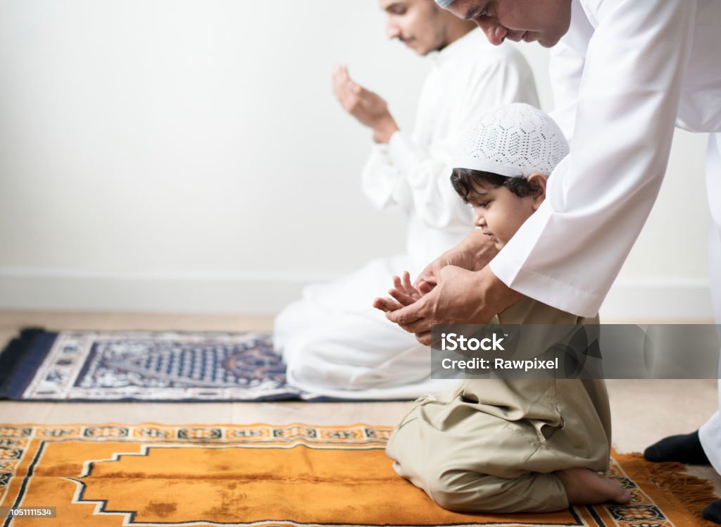 Muslim boy learning how to make Dua to Allah Islam Stock Photo