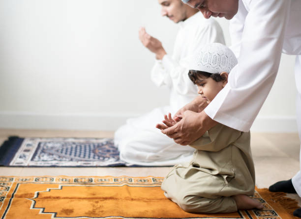 muslim boy learning how to make dua to allah - islam praying mosque ramadan imagens e fotografias de stock