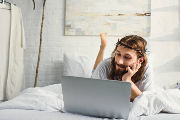 istock happy Jesus using laptop in bed during morning time at home 1051123192